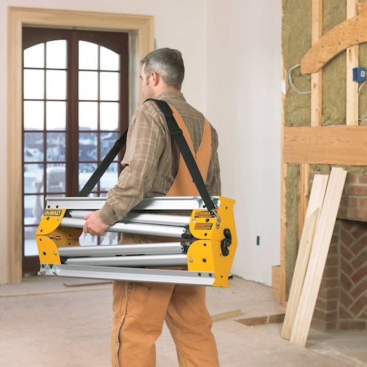 12 inch double bevel sliding compound miter saw being carried by a worker.