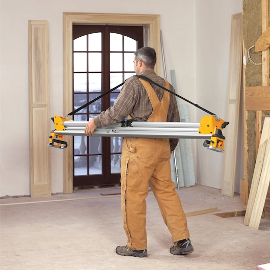 12 inch double bevel sliding compound miter saw being carried by a worker at a worksite.